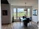 Sunlit dining room with an oversized window view, modern lighting, glass table and seating for four at 653 Glenarbor Cir, Longmont, CO 80504