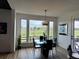 Dining area featuring a modern chandelier, views of the lush backyard, and sleek black dining chairs at 653 Glenarbor Cir, Longmont, CO 80504