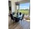 Bright dining room with a stylish chandelier and a large window overlooking the green neighborhood at 653 Glenarbor Cir, Longmont, CO 80504