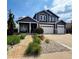 Two-story home featuring an attached three-car garage, well-manicured lawn, and welcoming front porch at 653 Glenarbor Cir, Longmont, CO 80504