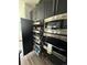 Custom kitchen pantry with pull-out shelves, stainless steel microwave, and oven appliances at 653 Glenarbor Cir, Longmont, CO 80504