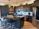 Kitchen with dark wood cabinets, granite countertops, large island, and stainless steel appliances at 653 Glenarbor Cir, Longmont, CO 80504