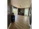 Cozy living room featuring modern light fixture, wood floors, dark accent wall, and sliding glass door to the outside at 653 Glenarbor Cir, Longmont, CO 80504