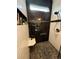 Shower showcasing white and black tiles, a shower bench, and modern fixtures at 653 Glenarbor Cir, Longmont, CO 80504