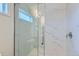 Close up of a bathroom shower with marble tile and a glass door at 6261 Red Cedar St, Frederick, CO 80530