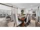 Charming dining room with rustic wood table, upholstered chairs, sliding barn door, and an open flow at 4733 S Vivian Ct, Morrison, CO 80465