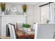 Formal dining area features a fireplace, white brick facade, and an elegant wooden dining table with cushioned chairs at 4733 S Vivian Ct, Morrison, CO 80465