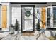 Close-up of a welcoming front door framed by elegant wood shutters and lush potted plants at 4733 S Vivian Ct, Morrison, CO 80465