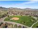 Aerial view of a neighborhood park, showcasing a baseball field, play structures, and walking paths at 4733 S Vivian Ct, Morrison, CO 80465
