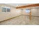 Spacious basement area featuring durable tile flooring, wooden beam and column, and natural light from two windows at 7701 Hillgate Way, Parker, CO 80134