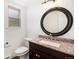 Bathroom boasts granite counters, a dark vanity, modern fixtures and a large, round mirror at 7701 Hillgate Way, Parker, CO 80134