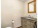 Powder room featuring a decorative wooden framed mirror and a vanity with stylish hardware and neutral cabinet at 7701 Hillgate Way, Parker, CO 80134