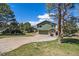 Landscaped front yard, mature trees, and a driveway leading to the charming two-story home's garage at 7701 Hillgate Way, Parker, CO 80134
