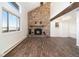 Bright living room features a stone fireplace, wood beam, large windows, and wood-look floors at 7701 Hillgate Way, Parker, CO 80134