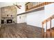 Spacious living room with stone fireplace, wood-look floors, and a stairway to the second level at 7701 Hillgate Way, Parker, CO 80134