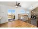 Bright living area with hardwood floors, stone fireplace, and large windows with a sliding glass door at 7701 Hillgate Way, Parker, CO 80134