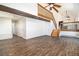 Open concept living room with wood-look floors, wooden stairway, and a connecting room at 7701 Hillgate Way, Parker, CO 80134