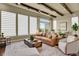 Bright living room with leather sofa, large windows, and wood floors at 10510 Ladera Dr, Lone Tree, CO 80124