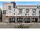 Street-level view of a modern multi-story townhome featuring brick and siding exterior at 4469 Tennyson St # 4, Denver, CO 80212