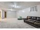 Spacious finished basement with a leather couch and carpeted floor at 9676 Rensselaer Dr, Arvada, CO 80004