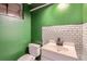 Basement bathroom with green walls and white tile at 9676 Rensselaer Dr, Arvada, CO 80004