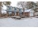 Two-story brick home with snow-covered lawn and attached garage at 1661 Red Fox Pl, Highlands Ranch, CO 80126