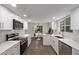 Modern kitchen with white cabinets, stainless steel appliances, and hardwood floors at 1661 Red Fox Pl, Highlands Ranch, CO 80126