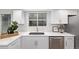 White kitchen with quartz countertops and a farmhouse sink at 1661 Red Fox Pl, Highlands Ranch, CO 80126