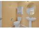 A half-bathroom with a pedestal sink, medicine cabinet and toilet with tile flooring at 3590 S Malaya St, Aurora, CO 80013
