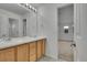 Bright bathroom boasts double sinks, wood cabinetry and an open doorway to the bedroom at 3590 S Malaya St, Aurora, CO 80013