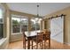 Bright dining area featuring wood floors, large windows, and a sliding barn door at 3590 S Malaya St, Aurora, CO 80013