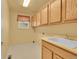 Laundry room with plenty of cabinet storage, a sink, and a window for natural light at 3590 S Malaya St, Aurora, CO 80013