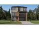 Two-story home featuring stone accents, a two-car garage, a balcony, and professionally landscaped front yard at 7740 S Cherokee Trl, Centennial, CO 80016
