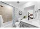 Modern bathroom with shower-tub, blue patterned shower curtain, vanity, and neutral tile at 17152 W 91St Ln, Arvada, CO 80007