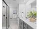 Bathroom featuring double vanities, shower with glass doors, and modern fixtures at 17152 W 91St Ln, Arvada, CO 80007