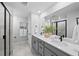Bright primary bathroom featuring double vanities, shower with glass doors, and modern fixtures at 17152 W 91St Ln, Arvada, CO 80007