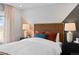 Bright bedroom featuring a unique headboard design, bedside tables, and soft natural light at 17152 W 91St Ln, Arvada, CO 80007
