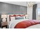 Comfortable primary bedroom featuring decorative wall paneling, chandelier, and side tables at 17152 W 91St Ln, Arvada, CO 80007