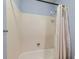 Bathroom featuring a tub with white tile surround and white shower curtain at 8236 Washington St # 29, Denver, CO 80229