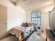 Bedroom with large window, vaulted ceiling beams, and neutral paint at 8236 Washington St # 29, Denver, CO 80229