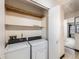 Functional laundry room with washer, dryer, shelves, and convenient access to nearby rooms at 8236 Washington St # 29, Denver, CO 80229