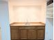 Basement wet bar with sink, wood cabinets, and open shelving at 420 E 104Th Pl, Northglenn, CO 80233