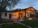 A covered outdoor patio with string lights leading to a lush backyard with an artificial turf play area at 3200 Ames St, Wheat Ridge, CO 80212