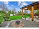 Backyard features a covered patio, fire pit, garden space, and well-manicured lawn at 3200 Ames St, Wheat Ridge, CO 80212