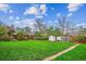 Spacious backyard with green lawn, garden shed, and a chicken coop enclosed by a wooden fence at 3200 Ames St, Wheat Ridge, CO 80212