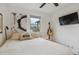 Bedroom with light colored walls and trim, hardwood floors, a ceiling fan and a wall mounted TV at 3200 Ames St, Wheat Ridge, CO 80212
