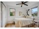 Bedroom with light colored walls and trim, hardwood floors, a ceiling fan and two windows at 3200 Ames St, Wheat Ridge, CO 80212