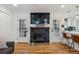 Close-up of the modern fireplace, flanked by French doors and opening to kitchen with breakfast bar at 3200 Ames St, Wheat Ridge, CO 80212