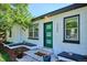 Welcoming front entrance with a green door, white brick, and attractive landscaping at 3200 Ames St, Wheat Ridge, CO 80212