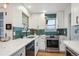 Updated kitchen features white cabinets, countertops, and green hexagon tile backsplash at 3200 Ames St, Wheat Ridge, CO 80212
